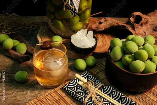 Ingredients and equipment for making Homemade plum wine or UMESHU on wooden table with black background. photo