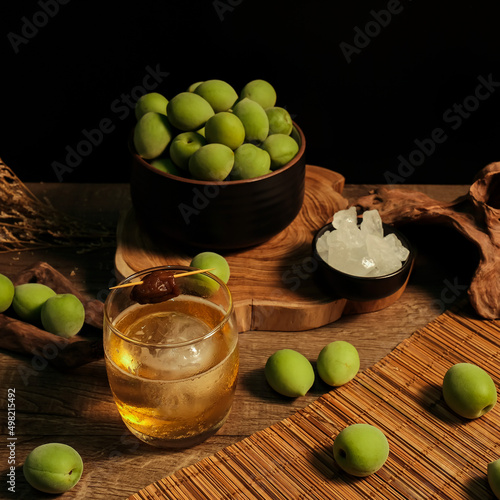 Ingredients for making Homemade plum wine or UMESHU on wooden table with black background.