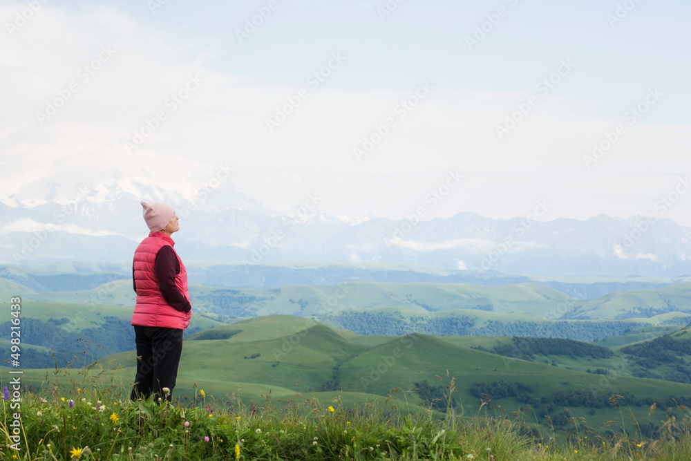 senior woman hiking in mountainous area. enjoy nature, have a good time. healthy lifestyle, leisure activity in old age. elderly travel. beautiful landscape