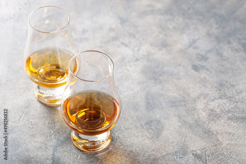 glass of whisky spirit brandy on gray concrete background © Olga Miltsova