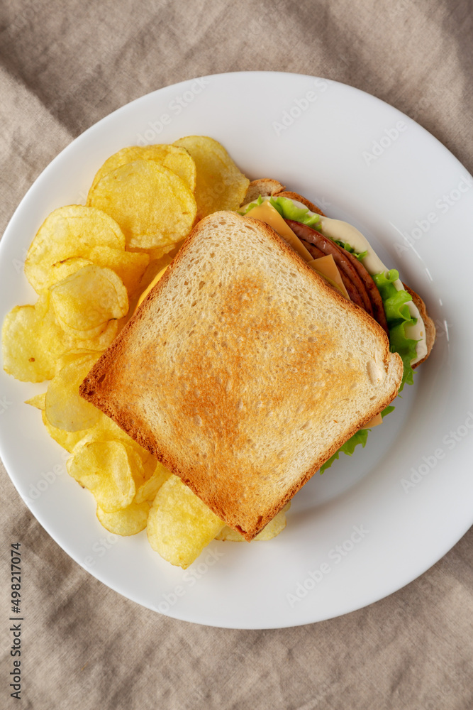 Homemade Fried Bologna and Cheese Sandwich with Chips on a Plate, top view. Flat lay, overhead, from above. Homemade Fried Bologna and Cheese Sandwich with Chips on a Plate, top view. Flat lay, overhead, from above.