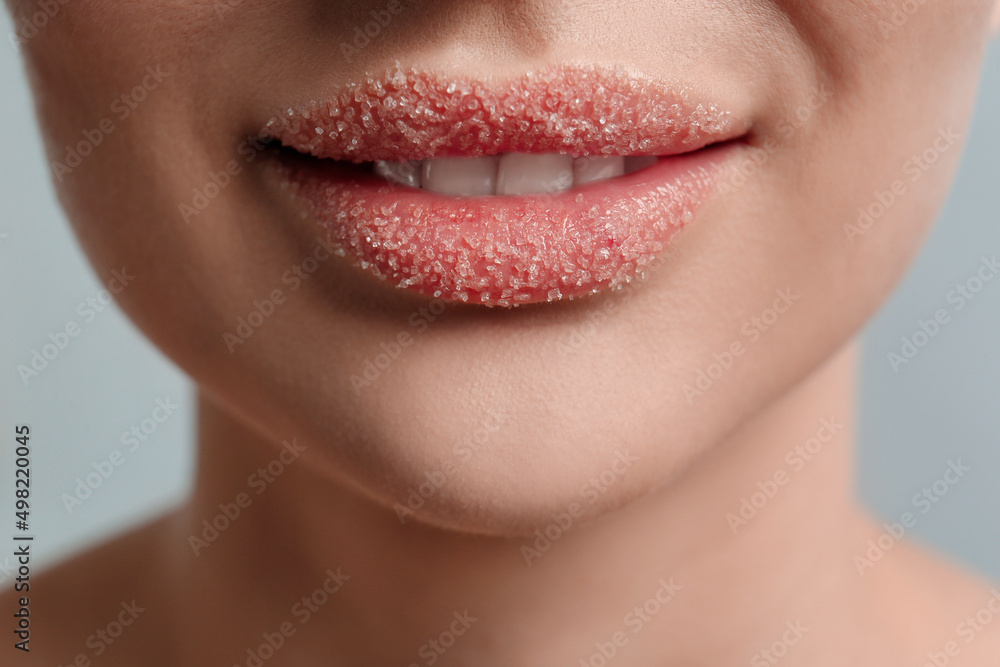 Fototapeta premium Closeup view of woman with lips covered in sugar on light grey background