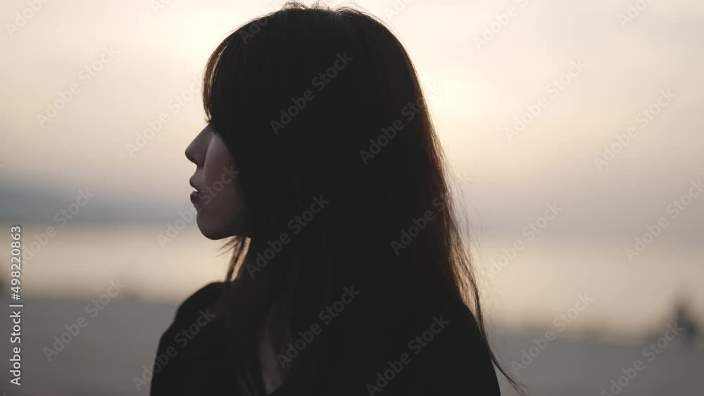夕暮れの海沿いで散策する女性 夕暮れの海沿いで散策する女性