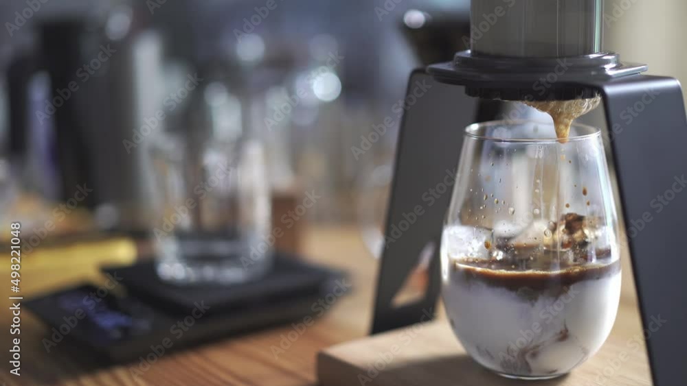 drop of espresso shot on a glass with ice and chilled milk, home brewing iced latte drop of espresso shot on a glass with ice and chilled milk, home brewing iced latte