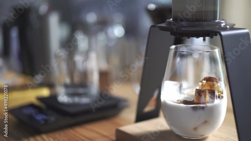 drop of espresso shot on a glass with ice and chilled milk, home brewing iced latte