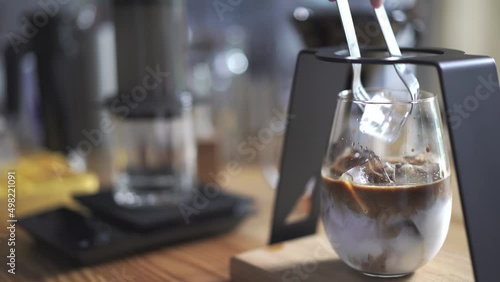 cube of ice add on glass of latte coffee, home brewing process