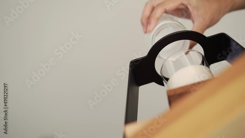 hand of barista pouring milk into small glass, worm eye view