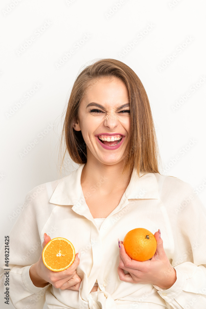 Young Caucasian smiling woman holding slices orange over isolated white background, breast health concept Young Caucasian smiling woman holding slices orange over isolated white background, breast health concept