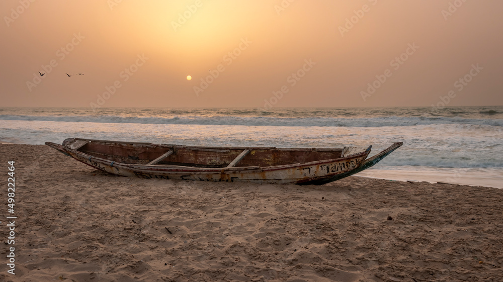 Abandon derelict fishing boat on Bijilo beach during sunset Gambia west African coast Abandon derelict fishing boat on Bijilo beach during sunset Gambia west African coast
