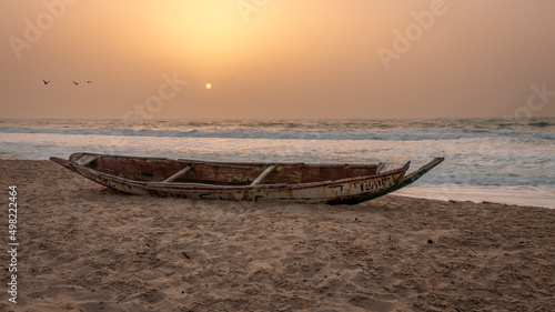 Abandon derelict fishing boat on Bijilo beach during sunset Gambia west African coast