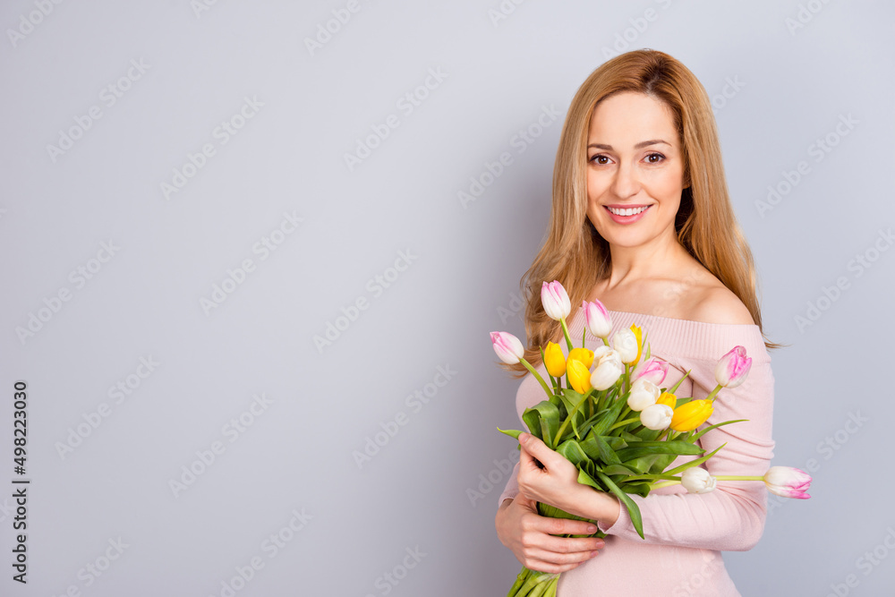 Portrait of cheerful charming person hold fresh flowers look camera isolated on grey color background