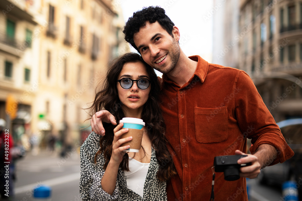 Traveling couple taking photos with camera. Loving couple walking through the city Traveling couple taking photos with camera. Loving couple walking through the city