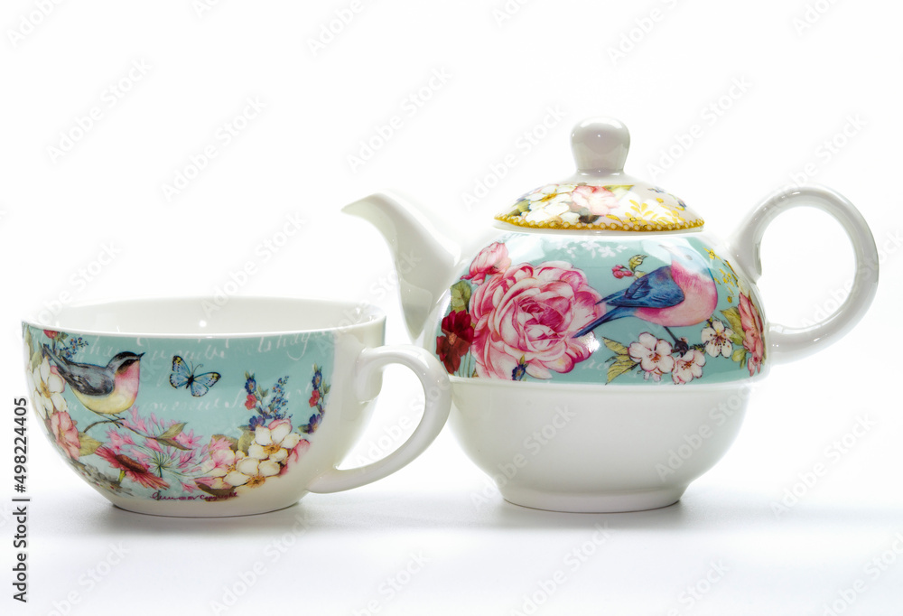 Porcelain teapot and cup with flower and bird pattern on a white background Porcelain teapot and cup with flower and bird pattern on a white background