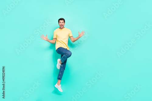 Full length portrait of astonished nice person arms palms open mouth isolated on teal color background