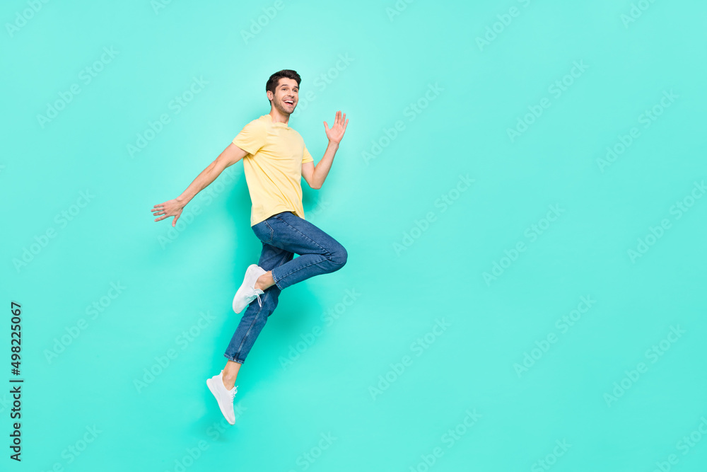 Full size profile portrait of crazy cheerful man jump empty space isolated on teal color background