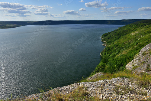 The panoramic landscape of Bakota Bay view. Dniester river, Ukraine. The banks of a large river with small waves on the water. Panoramic river, high banks, green hills. Summer day.