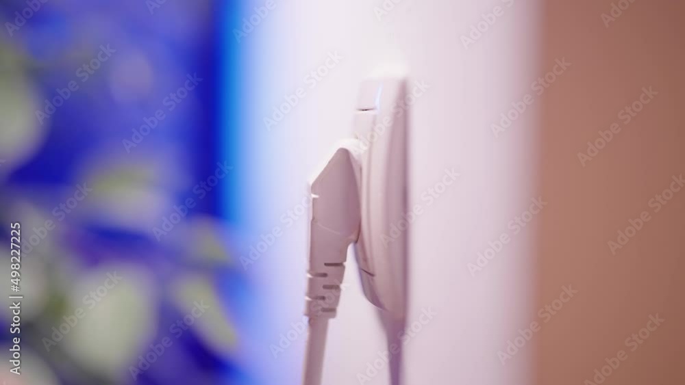 Plug in and plug out thick white cable turned downwards close-up 4K