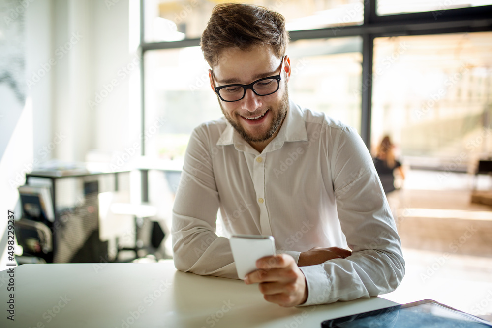 Portrait of a young business man using smart phone and working in cafe. Portrait of a young business man using smart phone and working in cafe.