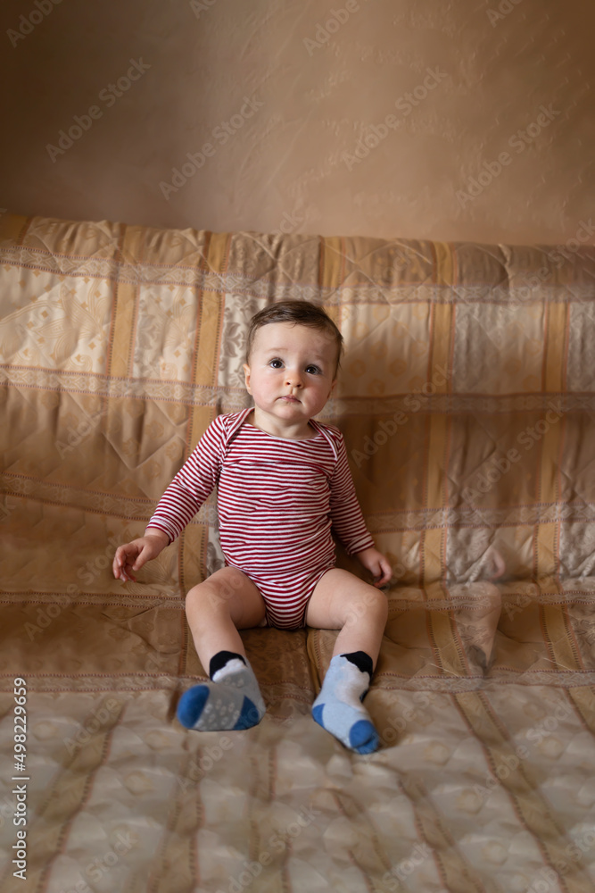 Naklejka premium Cute baby sitting in her outfit