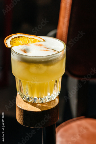 Alcoholic orange cocktail on the armrest of a chair. creative cocktail photo