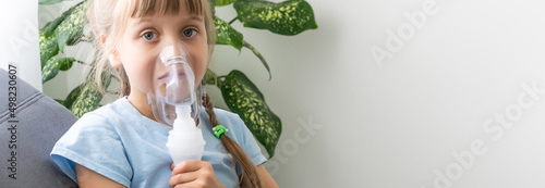 Little girl making inhalation with nebulizer at home. child asthma inhaler inhalation nebulizer steam sick cough concept.