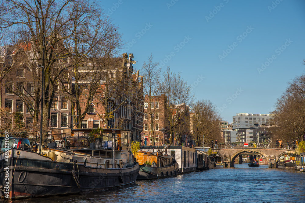 Naklejka premium Amsterdam, Netherlands, April 2022. The Prinsengracht in Amsterdam with the Westertoren and houseboats.