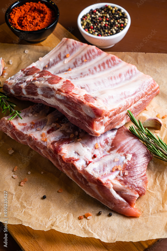 Raw ribs with rosemary on a wooden board Raw ribs with rosemary on a wooden board