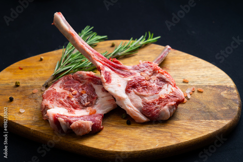 raw tomahawk with rosemary on a wooden board