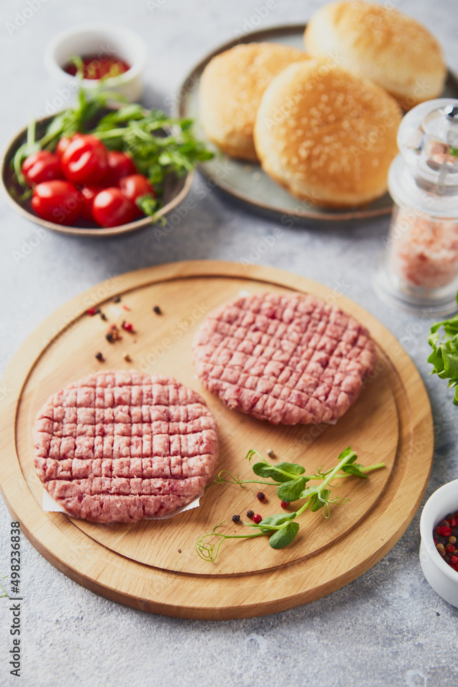 Raw veal mince Burger steak cutlets on wooden cutting board