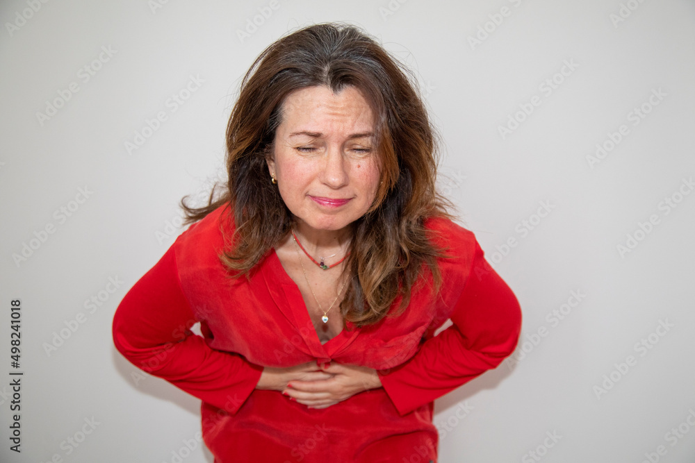 young woman having a stomachache. Young woman bends her arms to her stomach and suffers from menstrual pain. young woman having a stomachache. Young woman bends her arms to her stomach and suffers from menstrual pain.