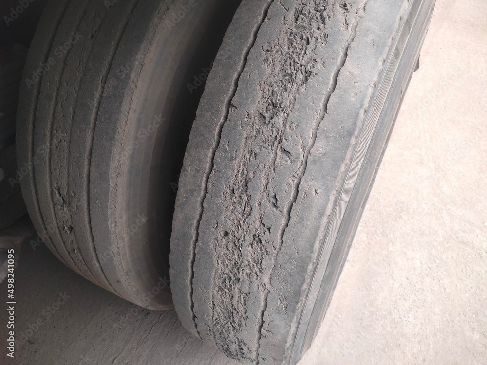 Old truck tire is damaged. Damaged and worn black rubber tubes are dangerous in use. Selective focus Old truck tire is damaged. Damaged and worn black rubber tubes are dangerous in use. Selective focus