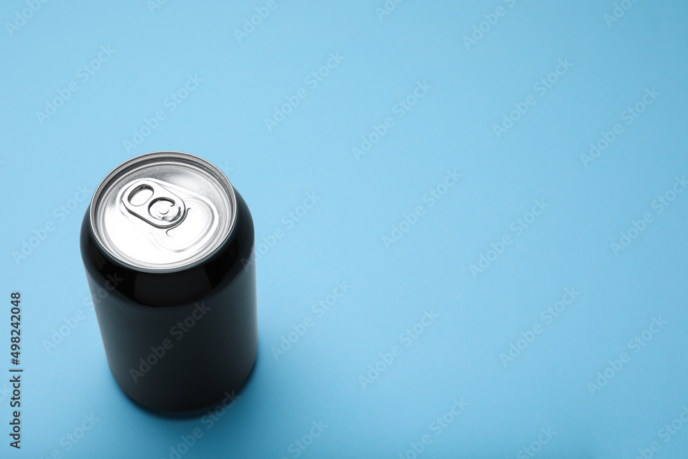 Black can of energy drink on light blue background. Space for text Black can of energy drink on light blue background. Space for text