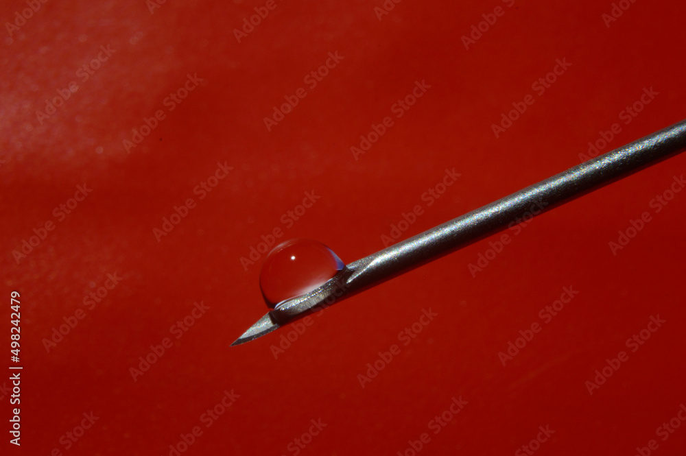 Syringe needle and a drop of a transparent substance. close-up Syringe needle and a drop of a transparent substance. close-up