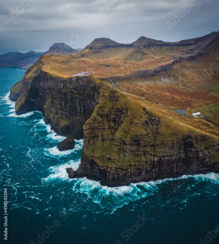 Flying a drone high above the Atlantic Ocean to capture the enormous cliffs of the Faroe Islands at Nordradalur. Streymoy island, november 2021 photo