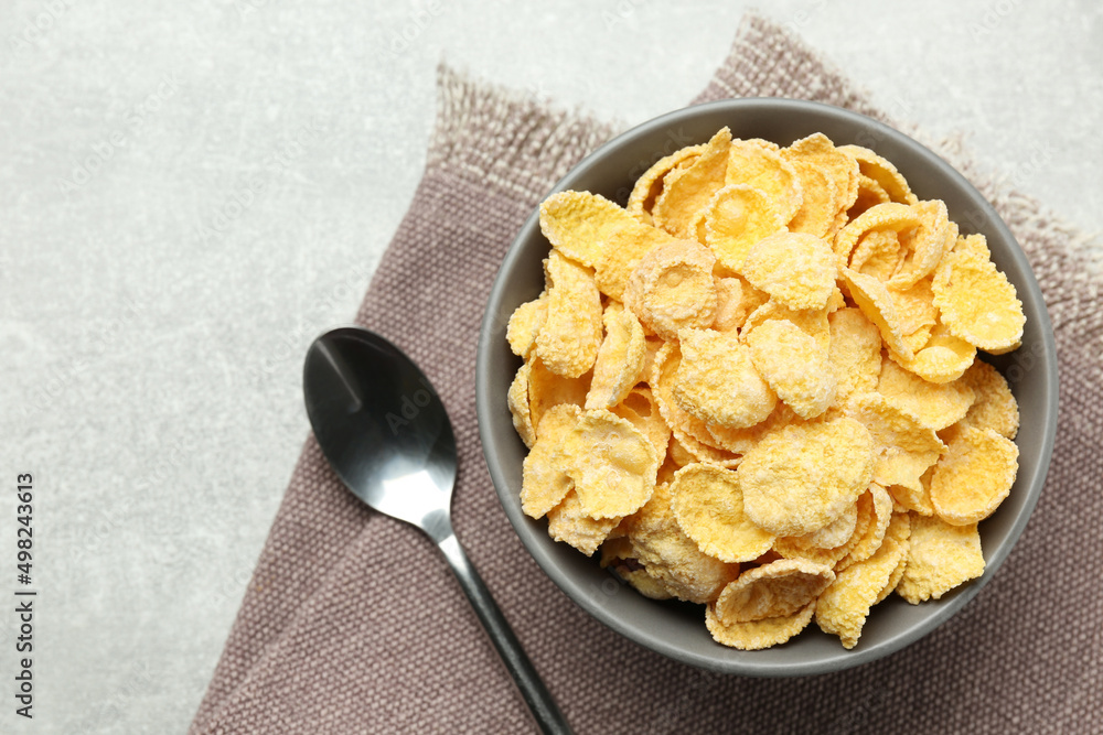 Bowl of sweet crispy corn flakes on light grey table, flat lay. Breakfast cereal Bowl of sweet crispy corn flakes on light grey table, flat lay. Breakfast cereal