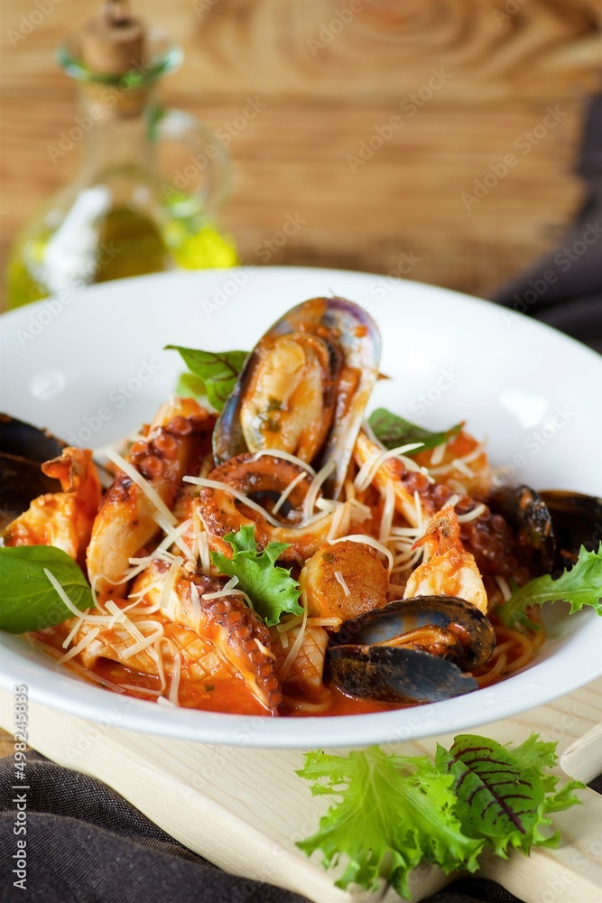 Seafood pasta - shrimp, clams and octopus served with cheese and basil leaves and red sauce Seafood pasta - shrimp, clams and octopus served with cheese and basil leaves and red sauce