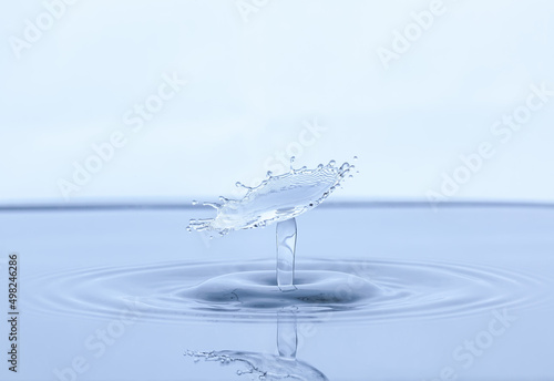 Splash and umbrella on white background. Reflection on the surface of the water.