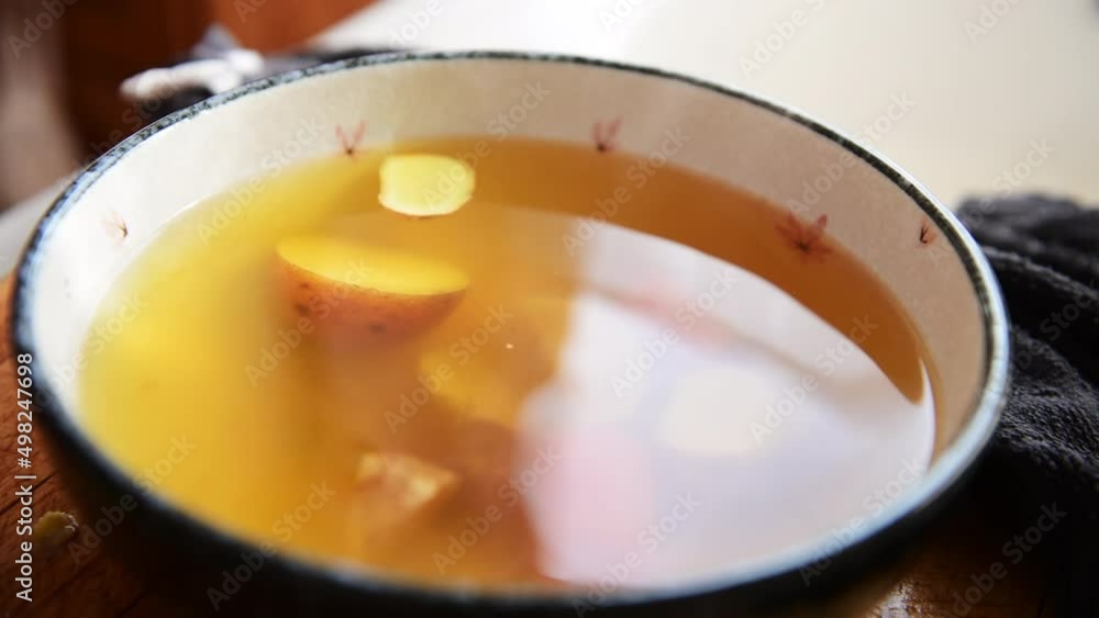 Putting ginger and green onion in soup. Putting ginger and green onion in soup.