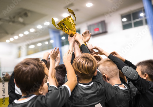 Cuadro en lienzo School sports teammates rising up golden trophy after winning sports indoor comp