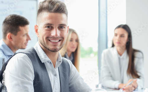 Businessman with colleagues in the background in office.