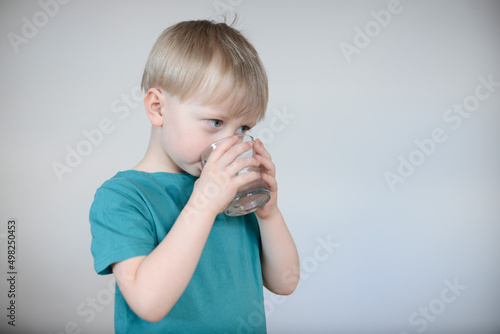 little blond boy drinks water