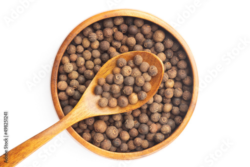 Spice Allspice in wooden bowl and spoon on white background. Flat lay. Brown color. Indian cuisine concept