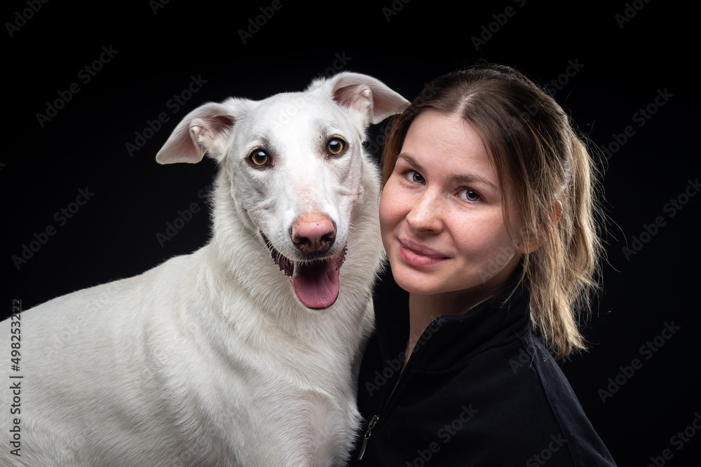 young pretty woman poses with her pet-white, highlighted on a black background.