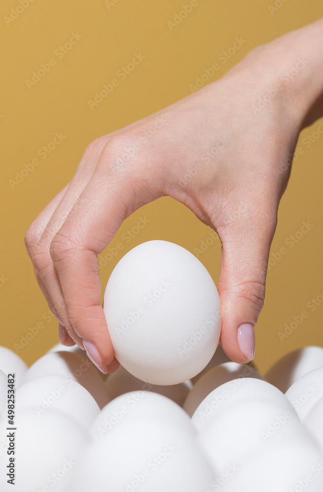 Hand takes an egg from a tray for painting for Easter Hand takes an egg from a tray for painting for Easter