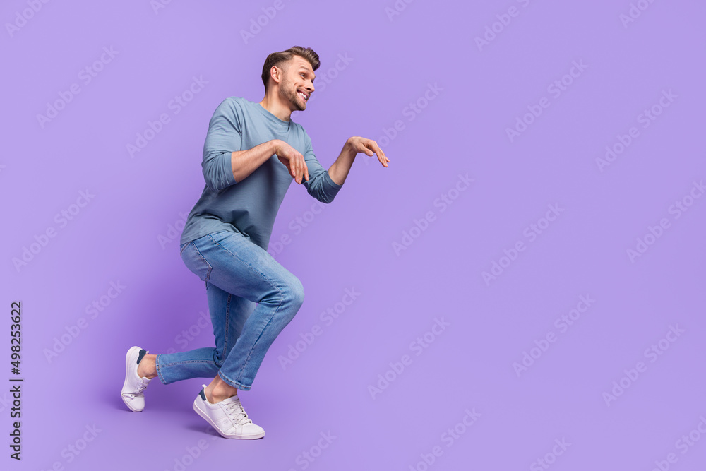 Full size photo of funky brown hairdo guy go wear shirt jeans sneakers isolated on violet color background