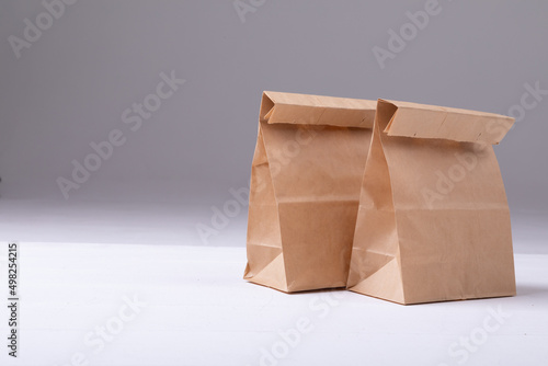 Close-up of brown paper lunch bags against white background with copy space