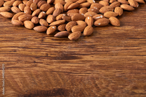 Close-up of nutritious almonds on wooden table with empty space