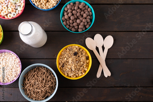 Overhead view of milk bottle by various breakfast cereals on table