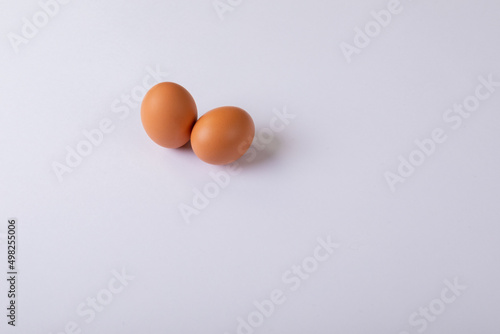 High angle view of two brown eggs on table with blank space
