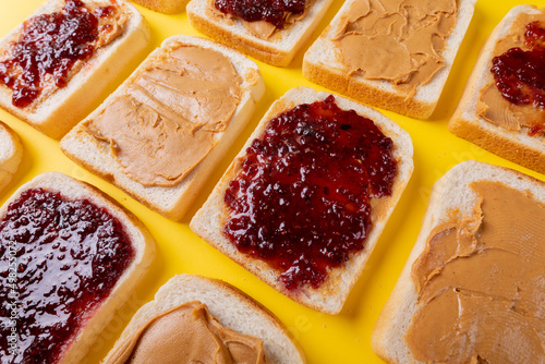 Full frame close-up of bread slices with preserves and peanut butter arranged alternatively
